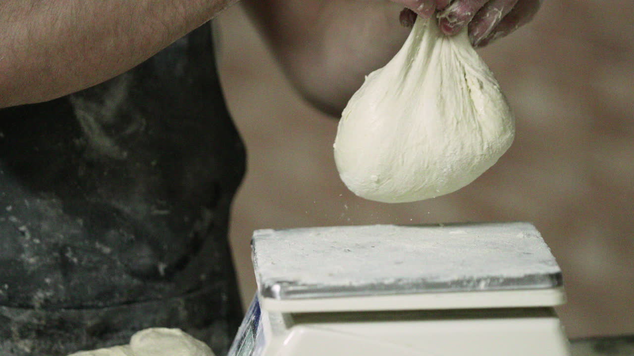 Panettiere che pesa l'impasto del pane su una bilancia da panificazione - rallentatore.