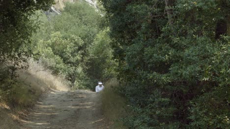 A-Braille-Institute-teacher-helps-a-blind-student-use-her-white-cane-to-walk-on-a-dirt-road-in-the-woods-California-1