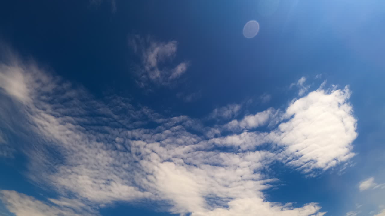 Timelapse: clouds in blue sky. Witness the swift movement of clouds as they change shape in the bright blue sky over a remote landscape