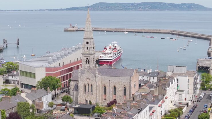 Vista panoramica del porto di Dún Laoghaire con chiesa storica e traghetto.