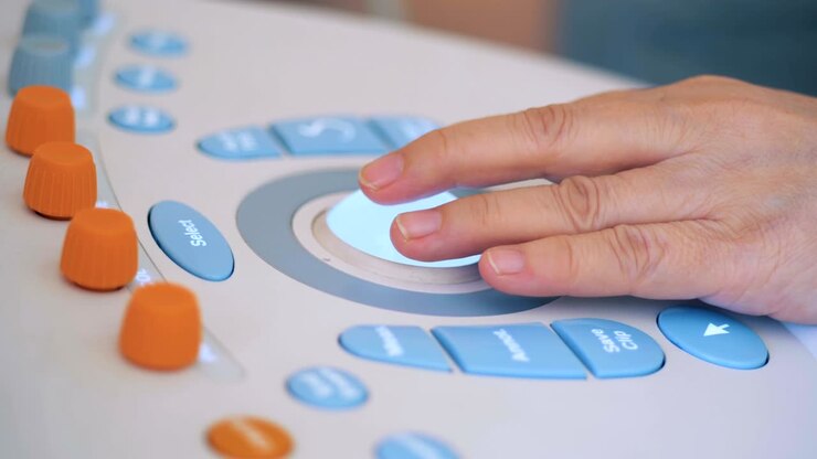 Close up of a hand manipulating an ultrasound console
