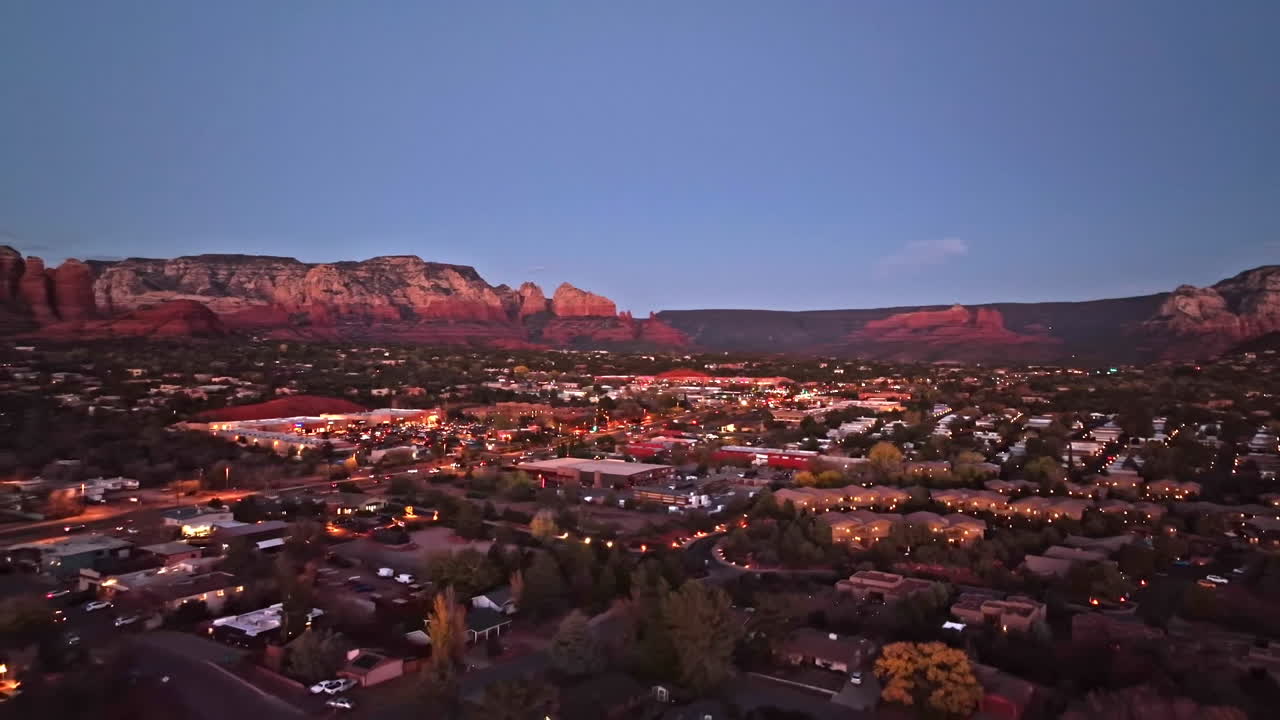 Cinematic revealing twilight drone shot of Sedona Arizona with traffic and homes