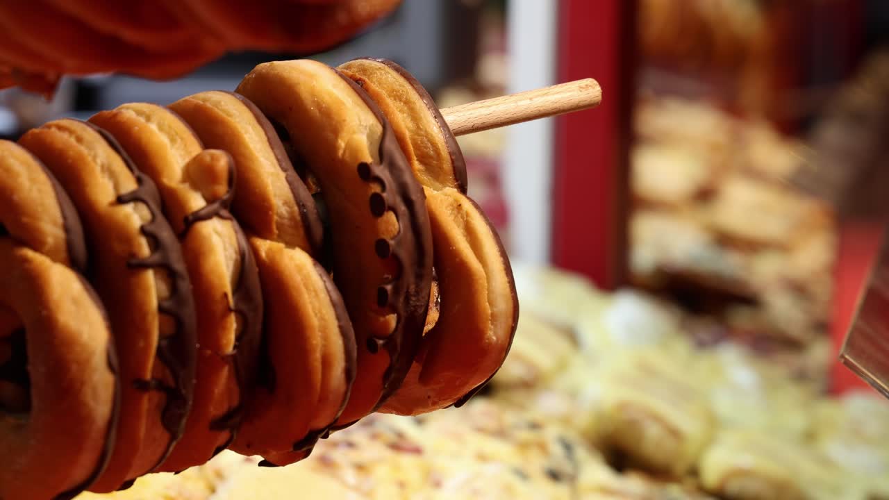 Chocolate covered donuts in pretzel shape on a food market