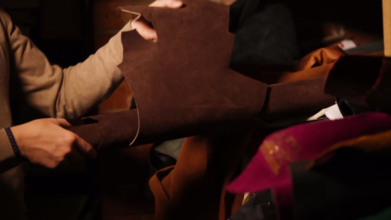 Leatherworker Handling Leather Roll in Workshop