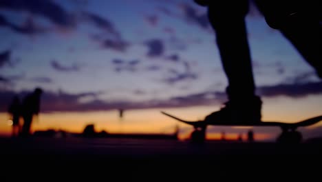 silhouetted skateboarder passing at sunset