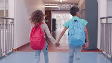 couple of schoolkids leaving school while hold hands