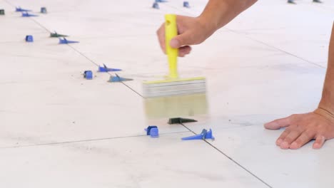 construction repair of laying ceramic tiles on a concrete floor the worker makes repairs in the