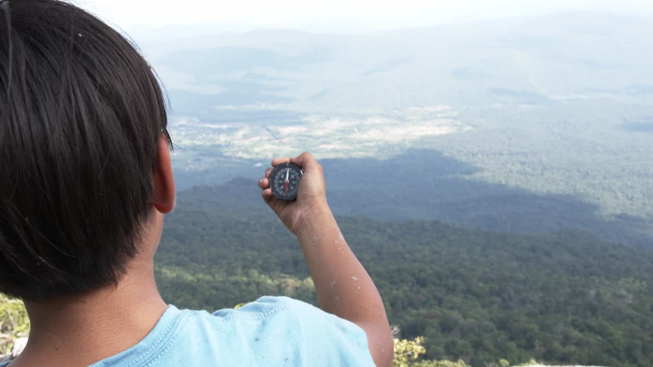 el niño tiene la brújula en la mano.