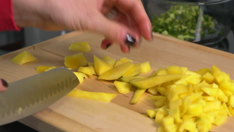 woman removing small pieces of mango skin for fresh salsa