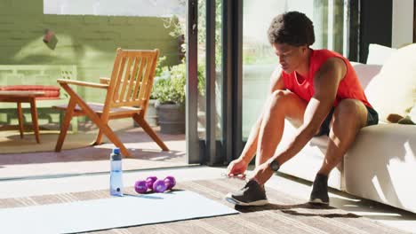 Colocar-A-Un-Hombre-Afroamericano-Haciendo-Ejercicio-En-Casa-Y-Atando-Los-Cordones.