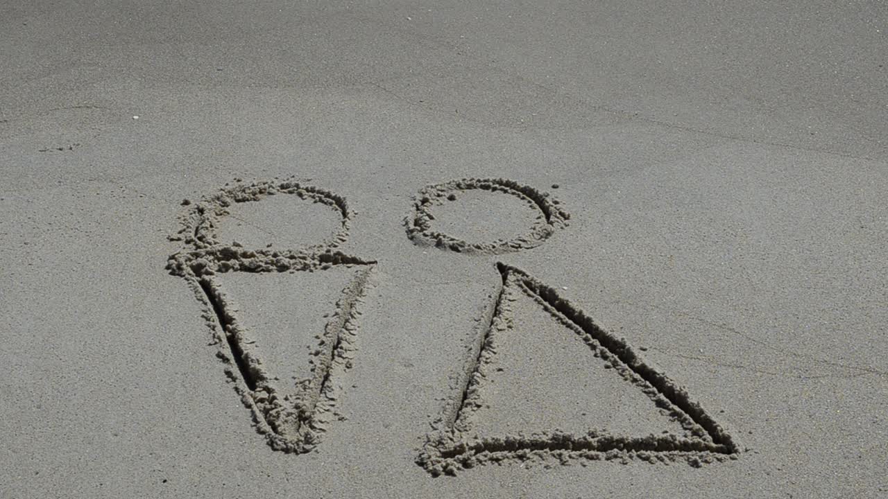 Disegno sulla sabbia che raffigura l'amore tra sessi opposti. Riprese in spiaggia.