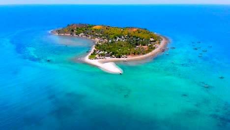 Aérea,-Una-Pequeña-Isla-Con-Playas-De-Arena-Blanca-En-Medio-Del-Océano-Azul-Claro