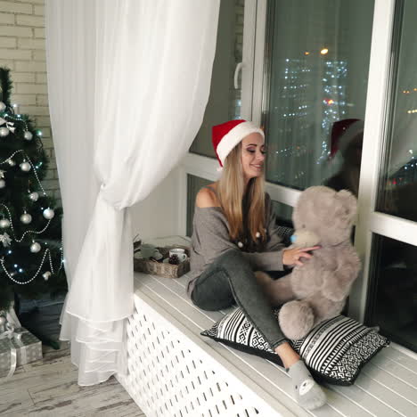 woman enjoying a christmas scene by the window