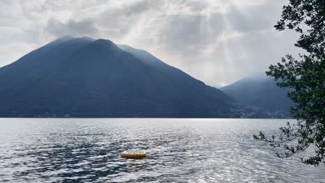 plano medio ancho del lago de como, italia con un pequeño bote de goma amarillo en primer plano