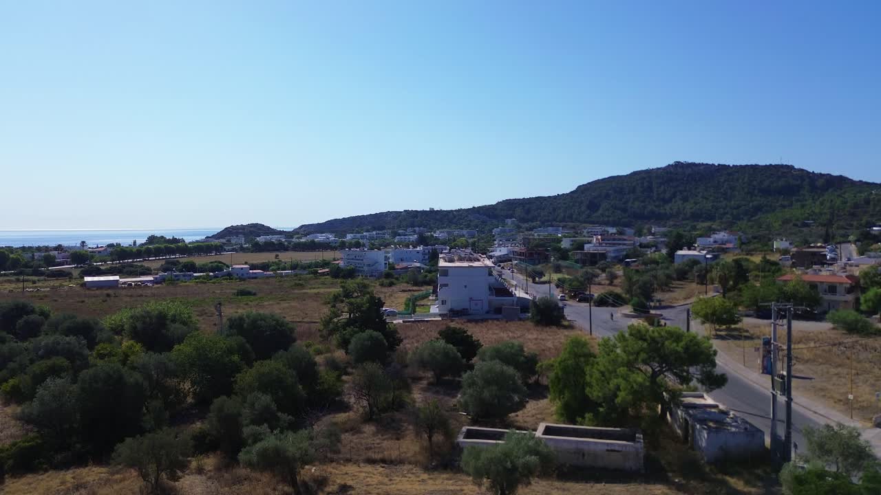 sobre la carretera y el bosque verde en rodas con la costa en el fondo en grecia durante el verano filmado con el avión no tripulado en 4k