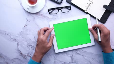 persona que utiliza una tableta con una pantalla verde
