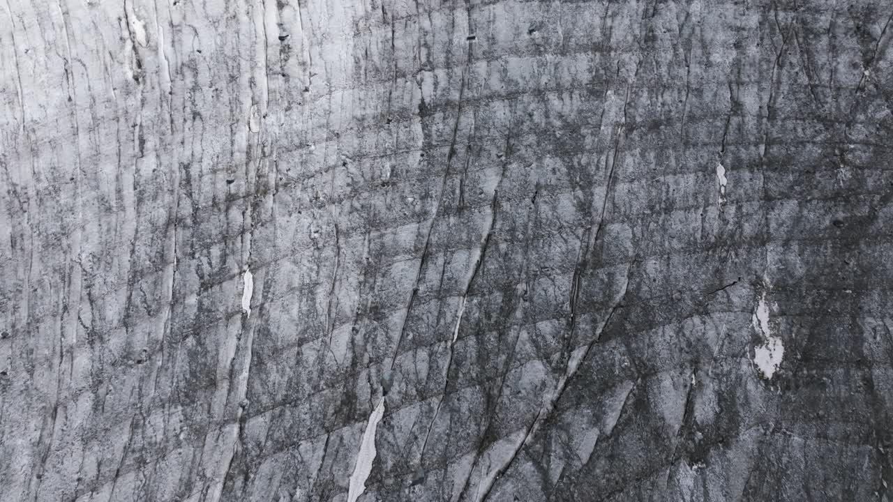 Surface of Fellaria Glacier with lagoon and mountains in background, Valmalenco in Italy