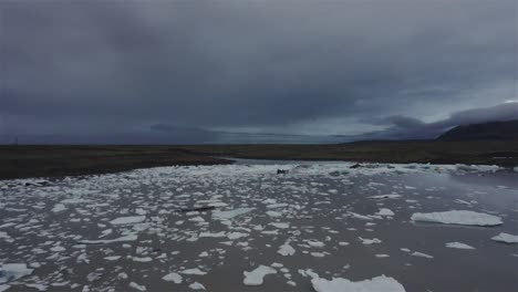 Drohne-Fliegt-Einen-Kreis-über-Einen-See-Mit-Eisbrocken-In-Richtung-Eines-Großen-Gletschers-In-Island-4k