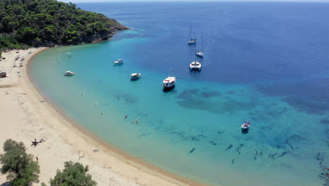 Luftaufnahme:-Panoramablick-Auf-Den-Strand-Der-Insel-Tsougkria-Mit-Vielen-Touristenbooten-Und-Segelbooten