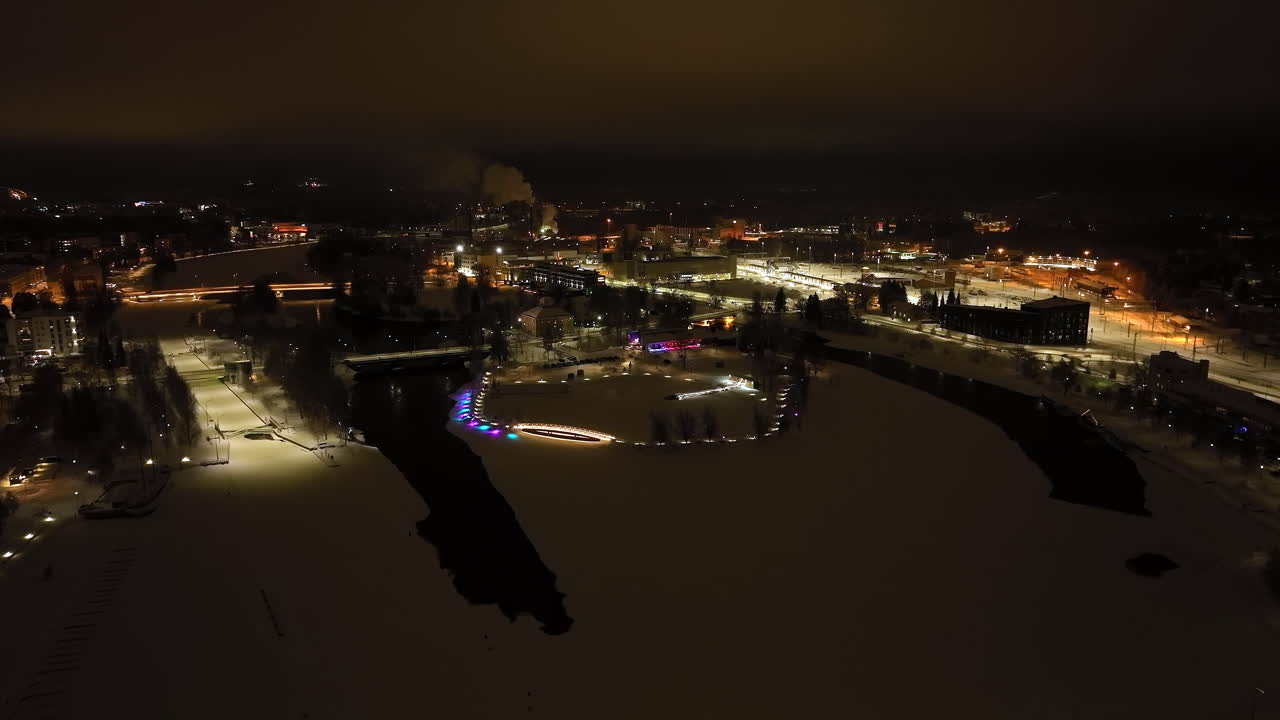 Establishing drone shot approaching the Ilosaari island, winter night in Joensuu