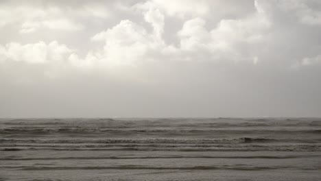 las nubes de tormenta gruesas y rápidas pasan sobre las olas agitadas y amenazantes azotadas por fuertes vientos antes de que la tormenta ciarán toque tierra