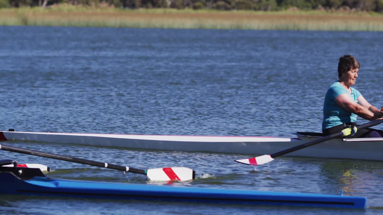 Four senior caucasian men and women rowing boat on a river