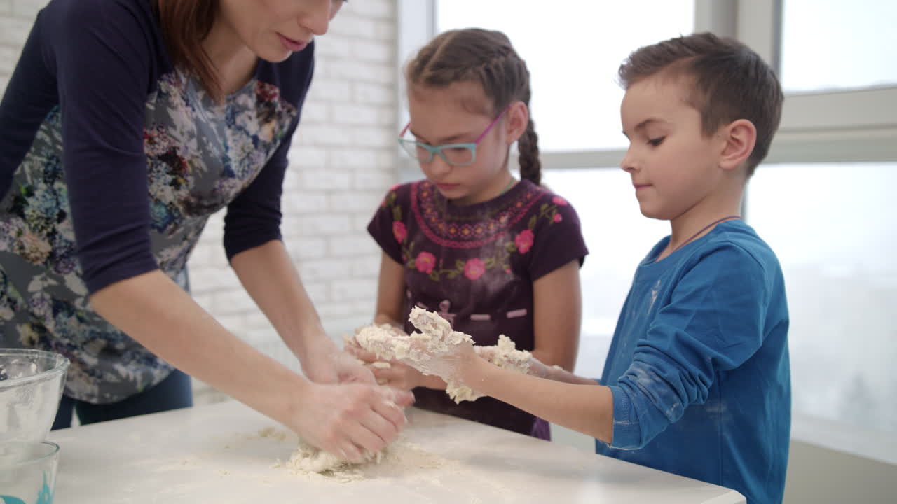 pequeño chef cocinando masa con mamá. niños cocinando masa con mamá
