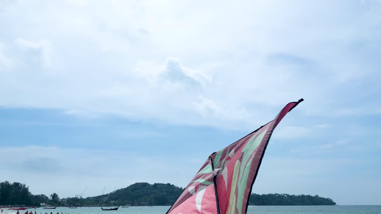 Un vibrante aquilone a ala delta vola contro un cielo blu sopra un paesaggio di spiaggia tropicale