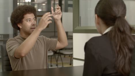 african american male in his 20's with a woman talking in an office setting with stable over the shoulder shot