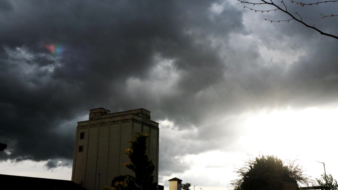 Graue Sturmwolken, die sich über einem hohen Gebäude auftürmen.