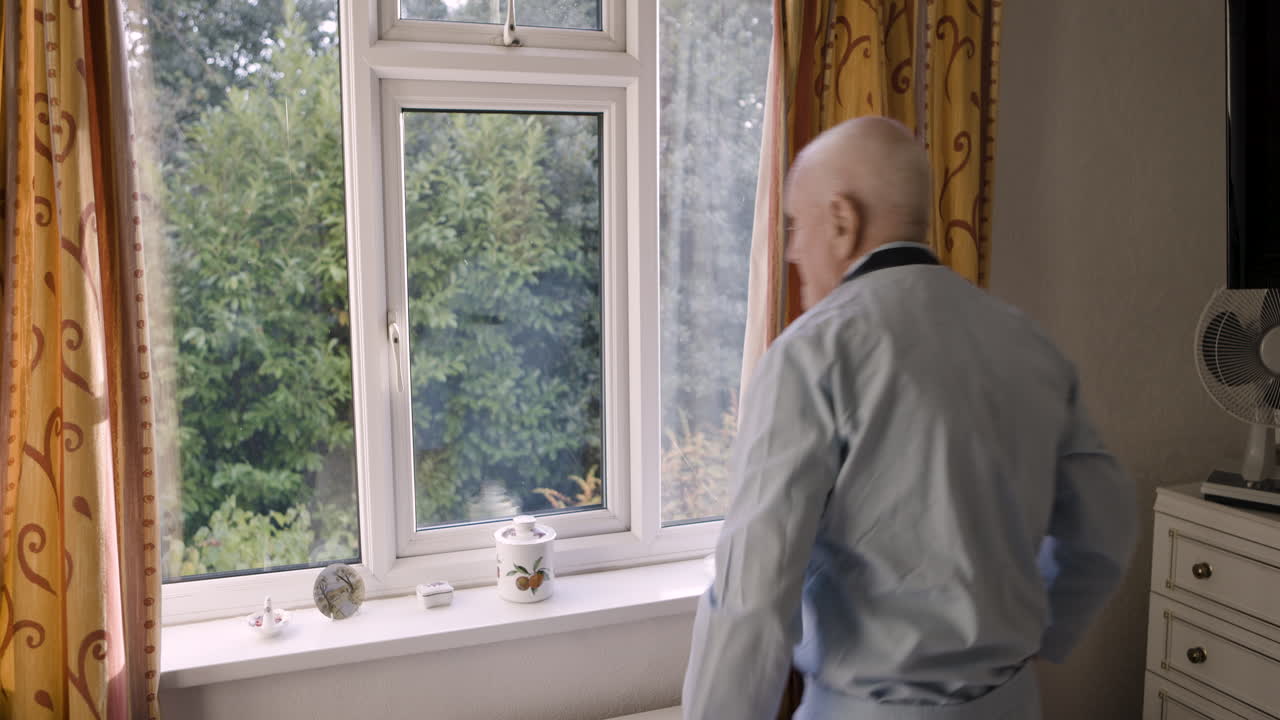 Elderly Man Looking Out Window