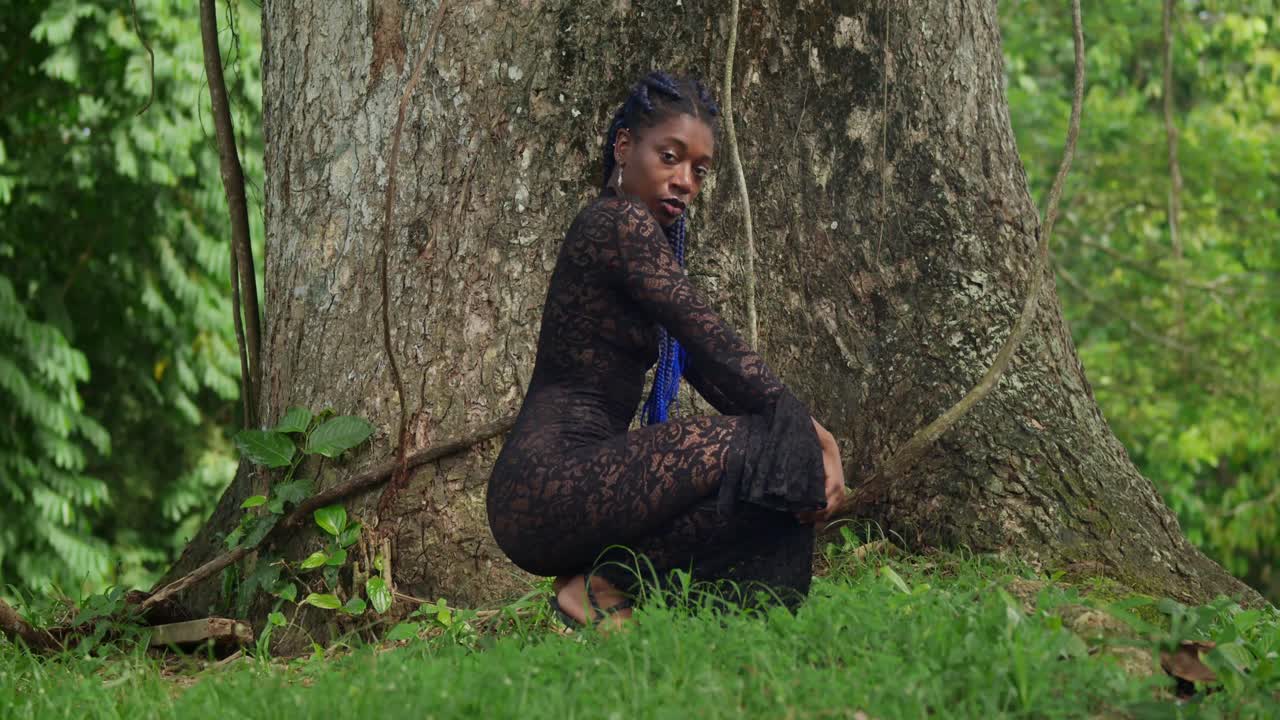 On the Caribbean island of Trinidad, a Black girl in a lace dress embraces the beauty of a tropical park.