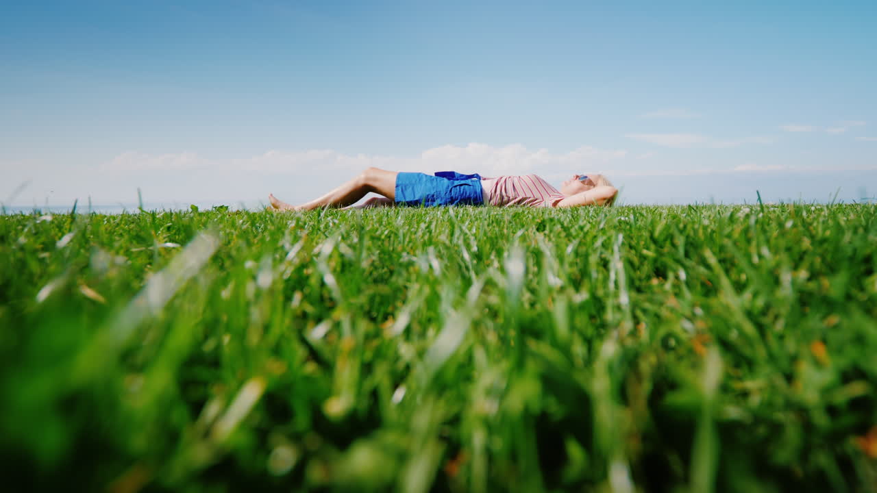 그 젊은 여자가 누워 있는 푸른 잔디밭은 하늘을 바라보며 쉬고 있다