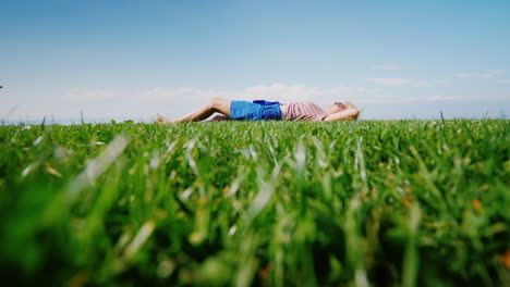 The-Green-Lawn-On-Which-The-Young-Woman-Lies-Looks-At-The-Sky-And-Has-A-Rest