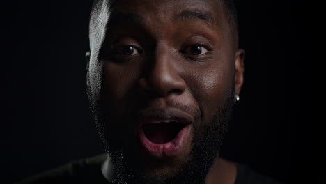 Joyful-man-posing-in-studio.-Happy-afro-guy-saying-wow-on-black-background