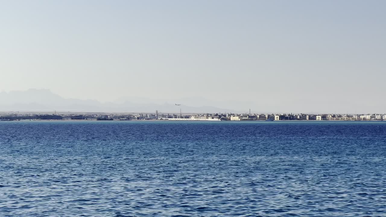 이집트 에 있는 은 바다 에서 허르가다 공항 에 착륙 하는 비행기 의 멀리 있는 모습