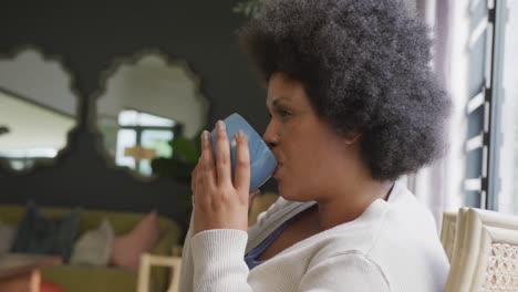 Video-of-relaxed-plus-size-african-american-woman-drinking-coffee