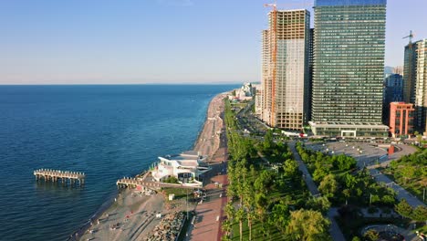 Flying-Along-Coastline-Of-Modern-Seaside-Town