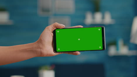 Nahaufnahme-Von-Frauenhänden,-Die-Ein-Horizontales-Mock-up-Greenscreen-Chroma-Key-Smartphone-Halten