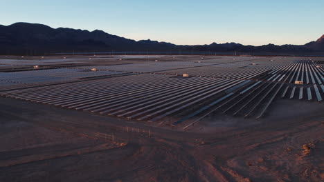 aerial view of big solar power plant and rows of solar panel in dry desert landscape of nevada usa, drone shot