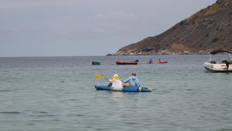 una pareja en kayak en el océano.