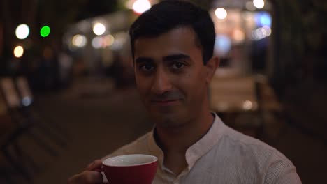man enjoying a drink at night
