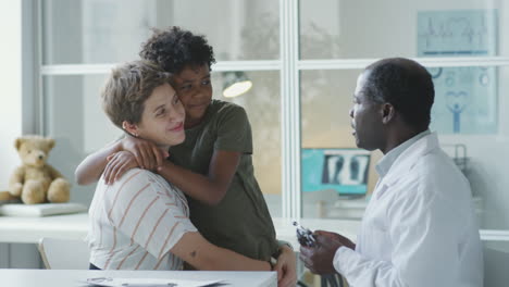 doctor examining a child with his mother