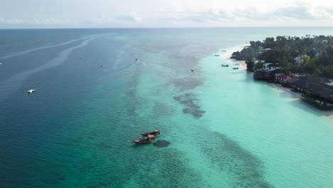 turquoise blue sea off coast of zanzibar, boats sailing. aerial flying forward