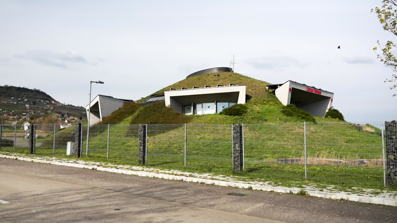Modern winery building integrated into a grassy hillside
