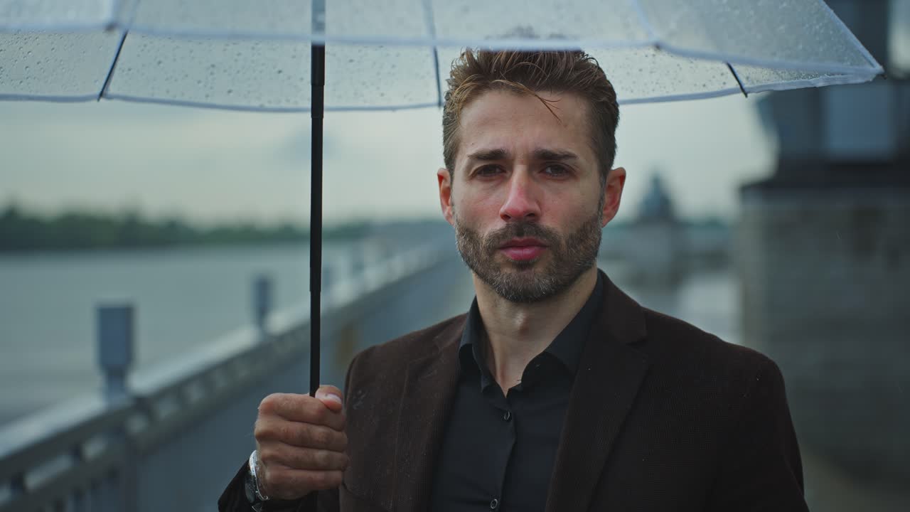 비가 오는 동안 우산을 들고 있는 남자