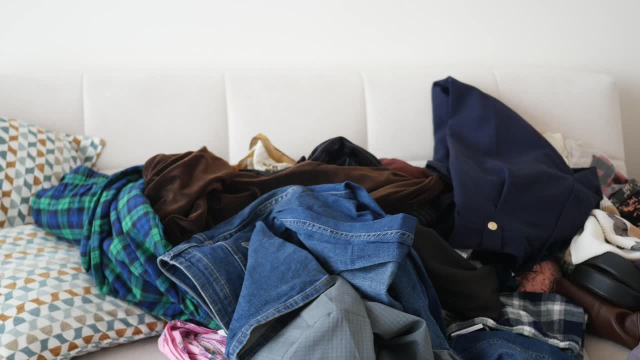 Messy clothes pile on sofa