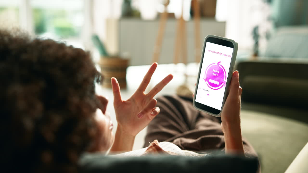 Woman using period tracker app on smartphone