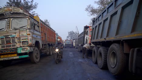 indian coal trucks waiting on a dusty road