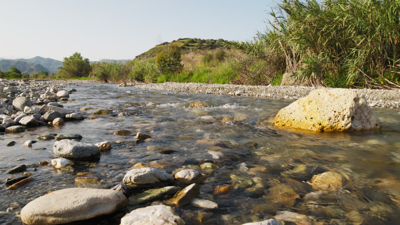In estate, un piccolo fiume d'acqua scorre tra le rocce in Sicilia